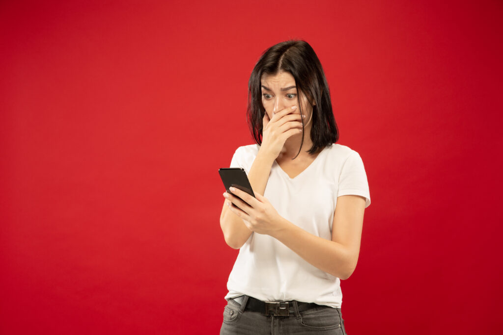 caucasian-young-woman-s-half-length-portrait-red-studio-background-beautiful-female-model-white-shirt-concept-human-emotions-facial-expression-buys-online-payment-bill-looks-shocked-1024x683 IA no Bolso: Vantagens e Desvantagens da Inteligência Artificial nos Smartphones